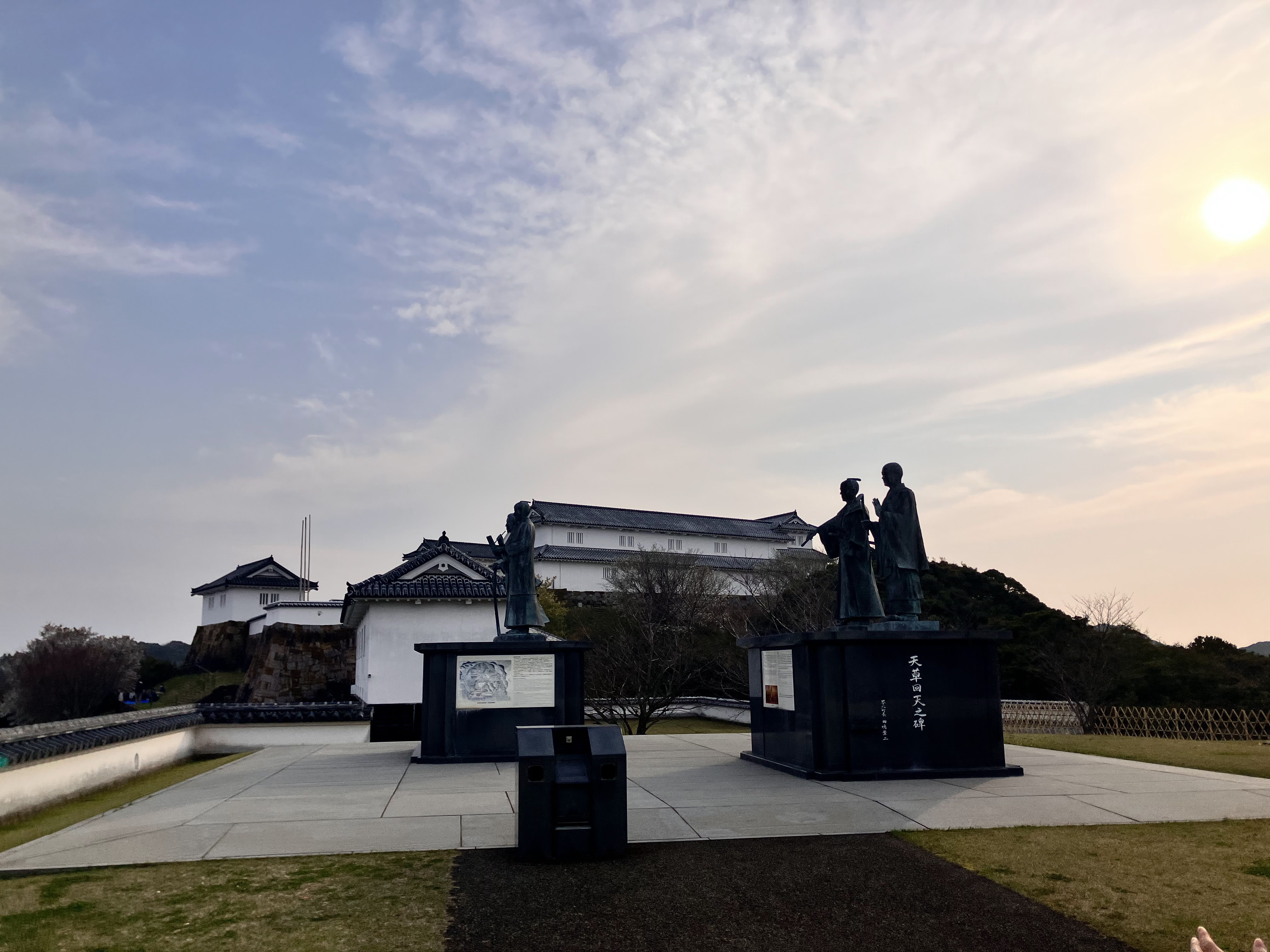 空の下に広がる富岡城跡の石垣と白壁、周囲のみどり